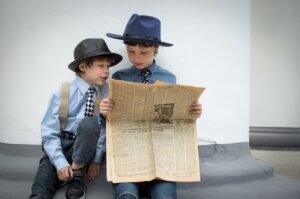 Zwei jungs lesen eine alte Tageszeitung.