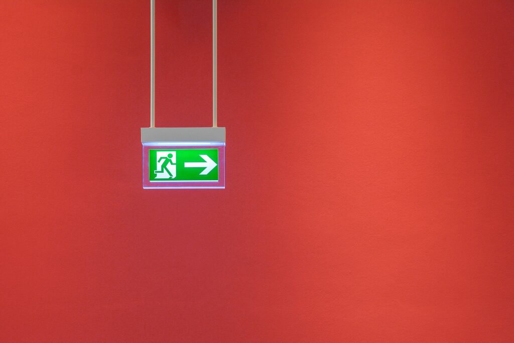 Exit Schild vor einer roten Wand.