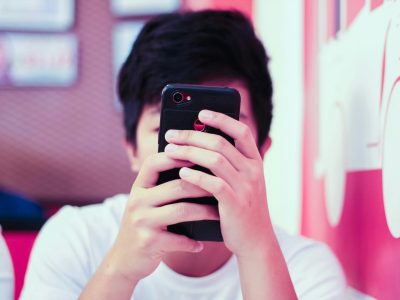 Junge mit Smartphone in der Hand.