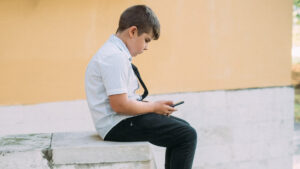 Trauriger Junge am Smartphone